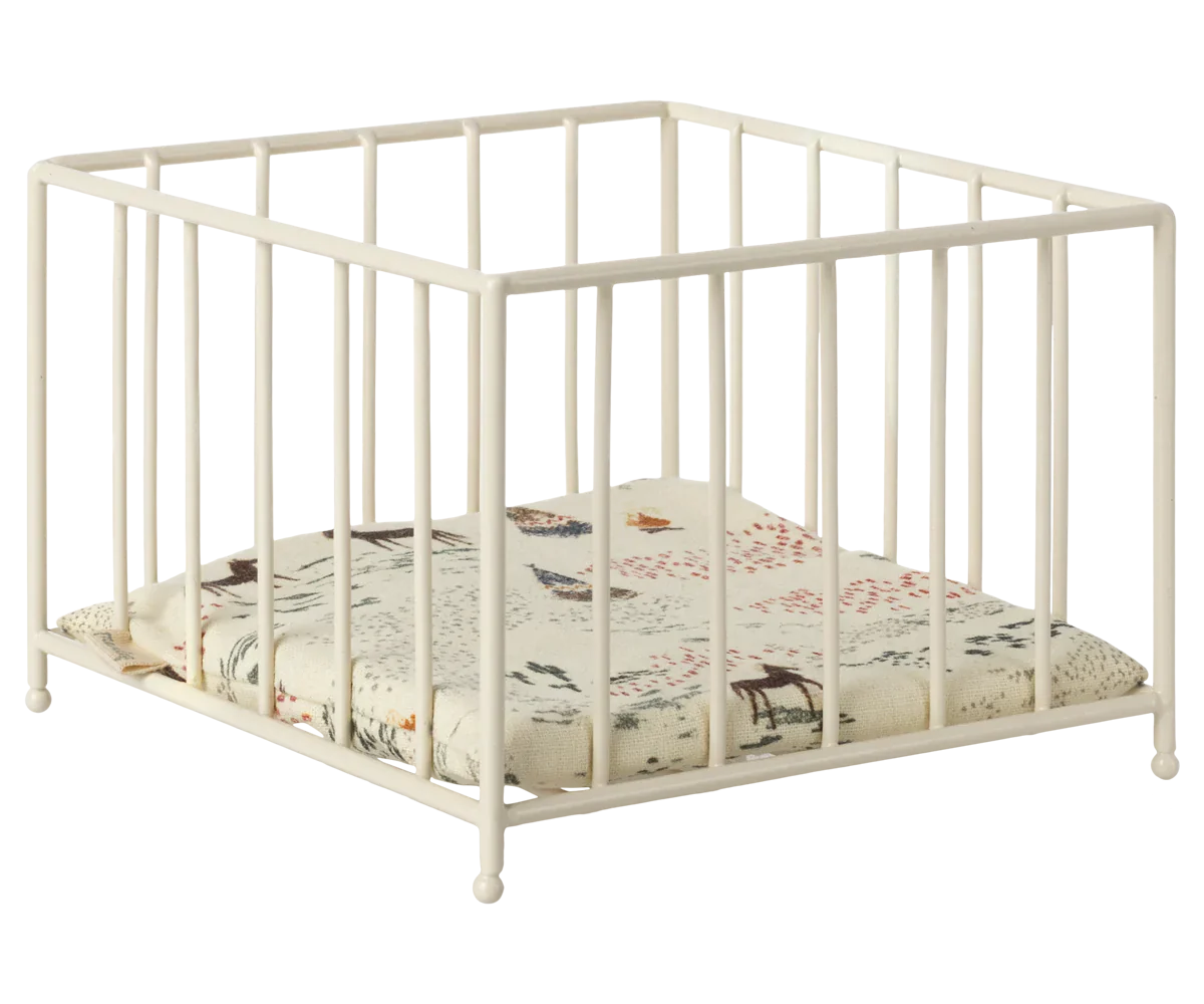 The Maileg Playpen, Micro by Maileg is a white square baby playpen with vertical bars and a cushioned base featuring a nature-themed print, perfect also as a small animal play area.