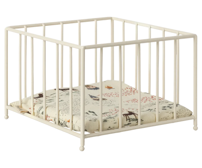 The Maileg Playpen, Micro by Maileg is a white square baby playpen with vertical bars and a cushioned base featuring a nature-themed print, perfect also as a small animal play area.