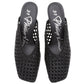 The 3.1 Phillip Lim ID Macrame Mule is a black, open-back slip-on with squared toes, handwoven faux leather, branded insoles, and an elegant architectural design.