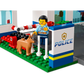 A toy police officer from the LEGO® City Police Station by Legos - Toyhouse stands proudly outside, petting a loyal police dog as a helicopter hovers in the background.