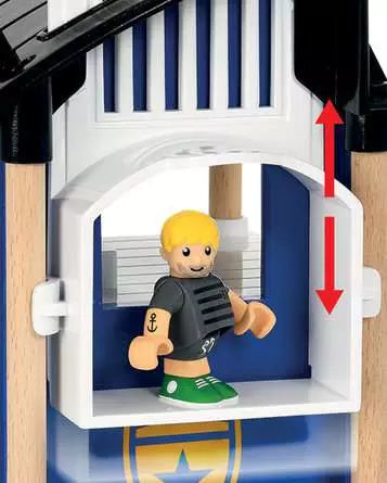 A toy figure featuring blond hair and green shoes is positioned inside the BRIO World Police Station, an imaginative blue and white playhouse by Brio. Red arrows suggest upward and downward movement, mimicking navigating through floors or possibly a daring escape from a tiny cell.