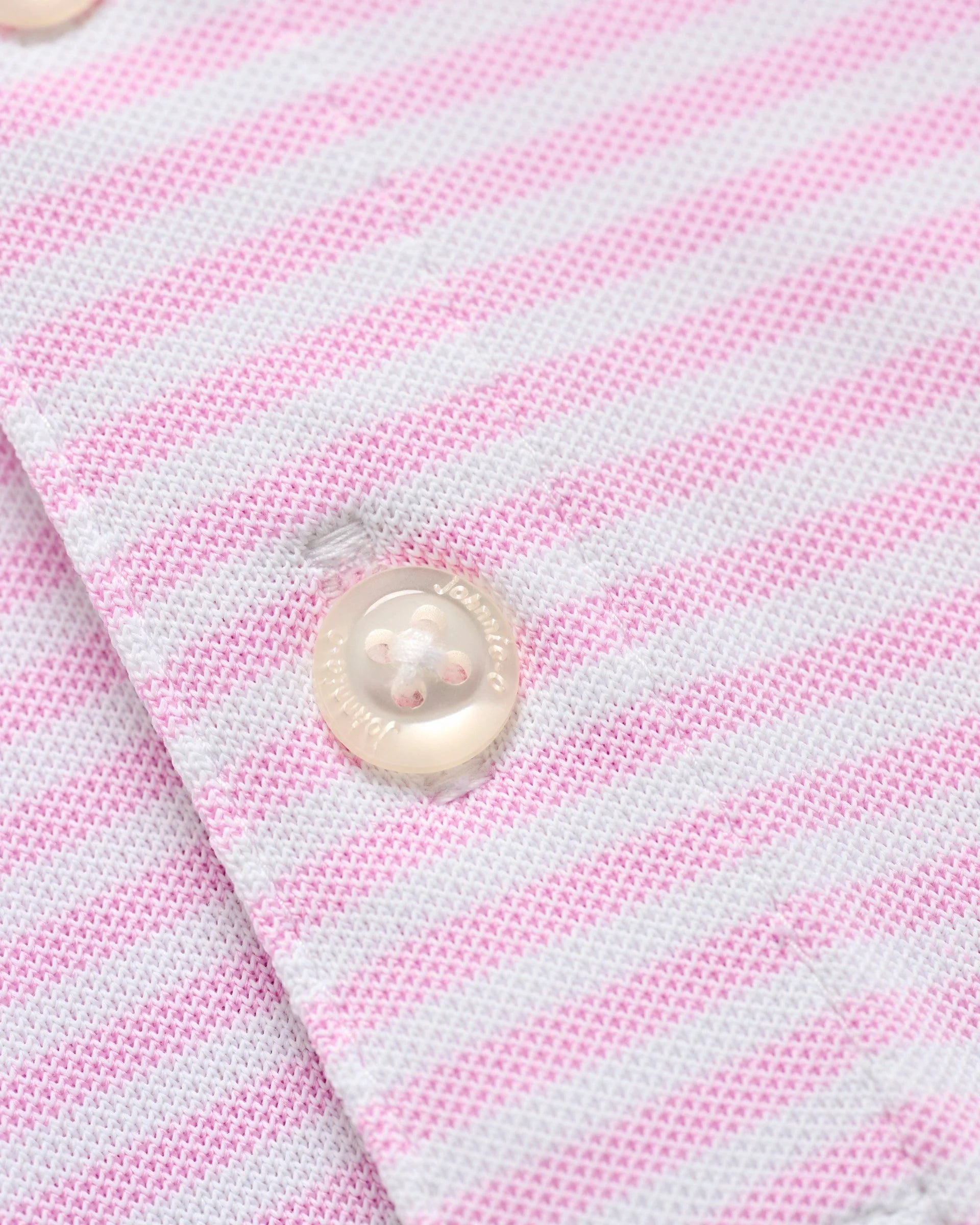 Close-up of the Johnnie-O Stetsons Polo, a pink and white striped lightweight fabric with two white buttons.