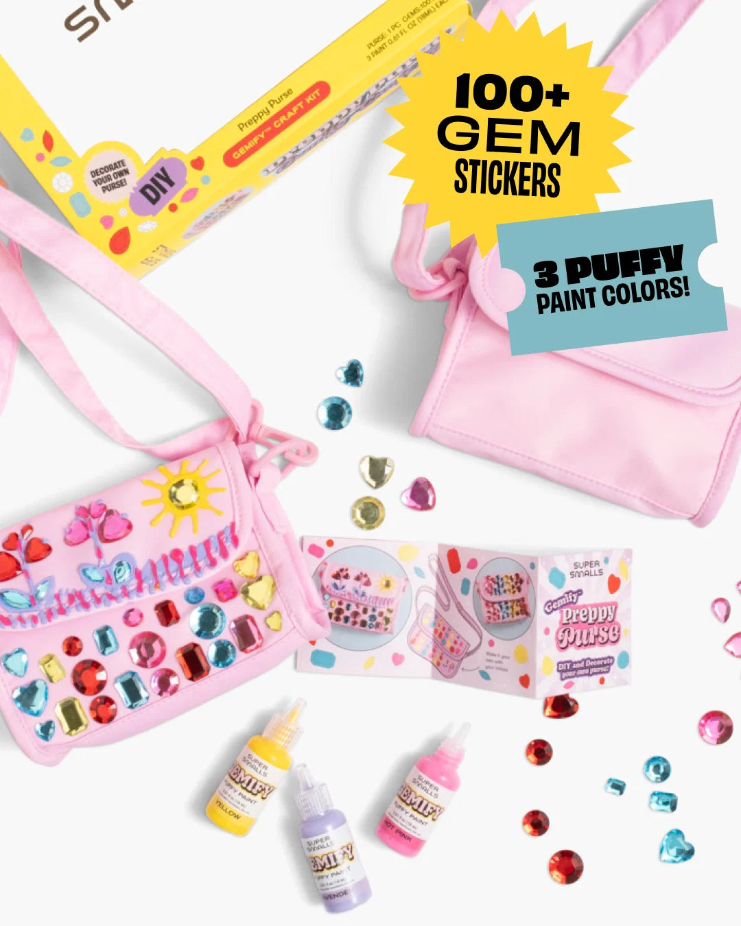 Two pink purses, gem stickers, paint bottles, and an instruction booklet from the Super Smalls Preppy Purse Gemify™ Craft Kit are arranged on a white background, showcasing a fun set for decorating your own stylish accessories.