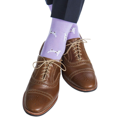 The Dapper Classics Dog Mid Calf Socks in lavender with white and brown pair beautifully with brown brogue shoes to create a sophisticated look. Made from mercerized cotton for added comfort, these socks feature a whimsical white dog pattern that adds a playful touch to any ensemble.