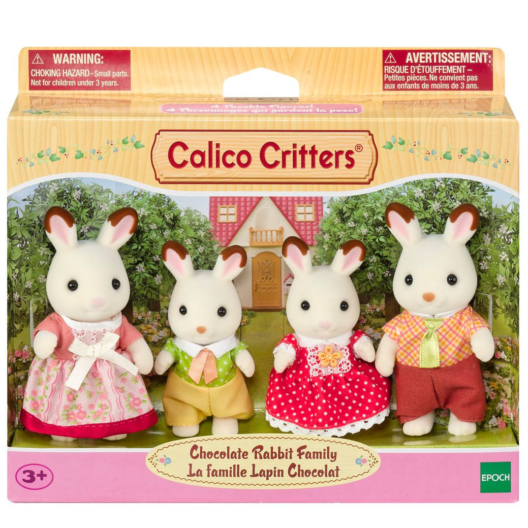 Boxed set of four Calico Critters Chocolate Rabbit Family posable figures, dressed in colorful clothes, with a background featuring a house and trees. Perfect for any fan of collectible toys.