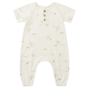 The Quincy Mae Baby Short Sleeve Jumpsuit features a cream color, three coconut buttons, a chest pocket, and a subtle animal and tree print—designed for babies with easy changing in mind.