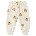 The Quincy Mae Baby and Kids’ Relaxed Fleece Sweatpant Pumpkins feature a cozy cream-colored design with an all-over print of smiling cartoon pumpkins, complete with an elastic waistband and drawstring for everyday comfort.