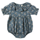 The Quincy Mae Baby Girls' Collared Romper features short sleeves, a ruffled collar, and a blue fabric with a white floral print and ruffle details.
