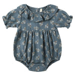 The Quincy Mae Baby Girls' Collared Romper features short sleeves, a ruffled collar, and a blue fabric with a white floral print and ruffle details.