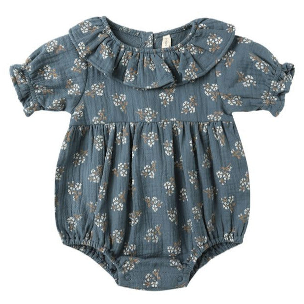 The Quincy Mae Baby Girls' Collared Romper features short sleeves, a ruffled collar, and a blue fabric with a white floral print and ruffle details.