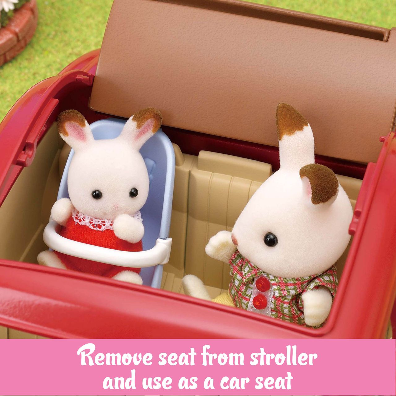 Two Calico Critters toy rabbits are seated in the red Family Cruising Car, with one sitting in a removable blue car seat. A pink banner at the bottom explains how to use the seat as a car seat, making this Calico Critters family vehicle perfect for adventures around Calico Village.