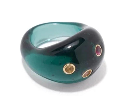 A Lizzie Fortunato Monument Ring with a modern design, featuring a deep green color and embellished with multiple inlaid stones or gems of different colors, displayed on a white background.