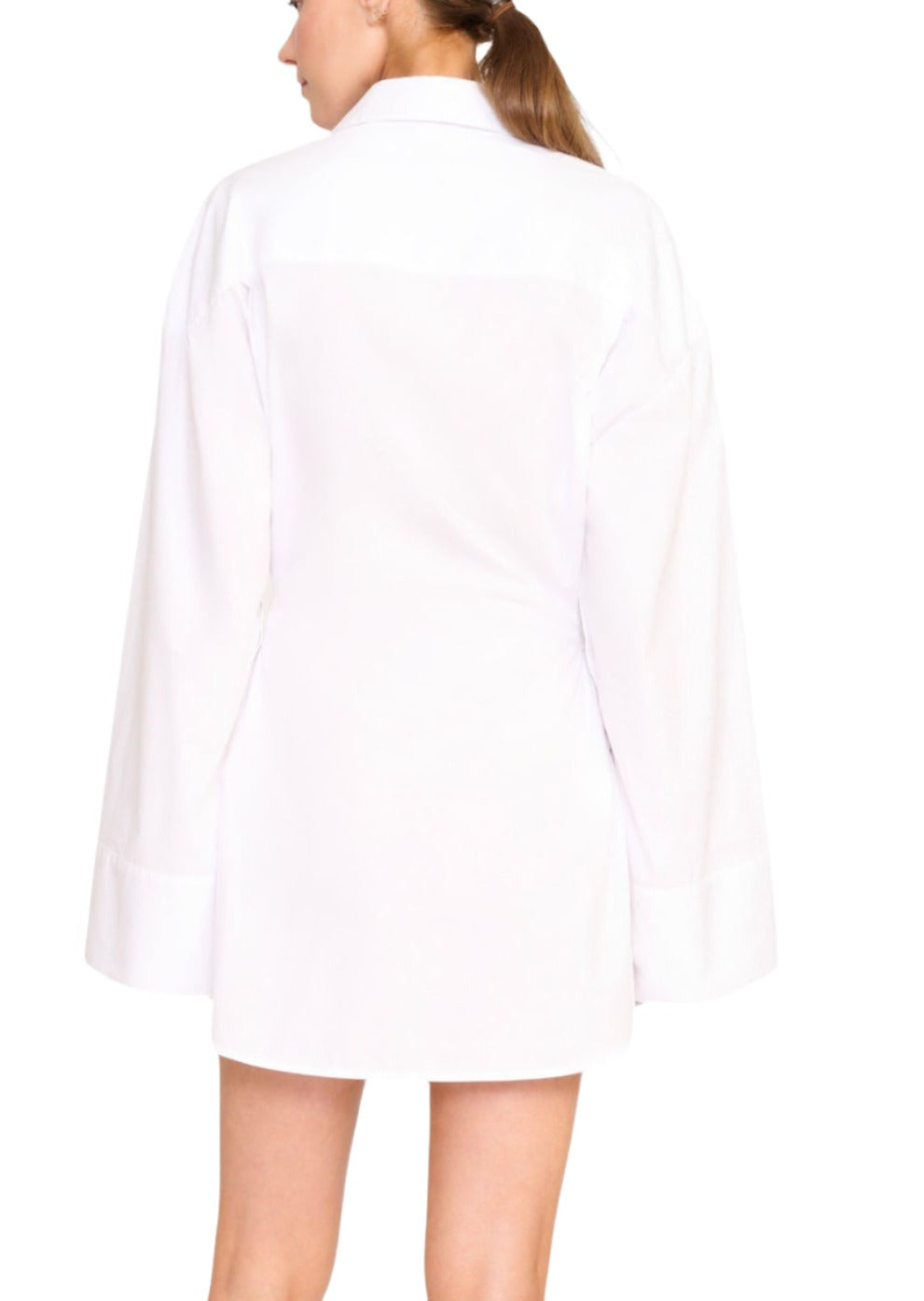 A person with a ponytail is standing and facing away, wearing the Staud Cindy Dress by Staud in stretch cotton poplin and black shoes. The background is plain white.