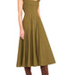 A person is wearing the Staud Wells SS Dress in olive green with short sleeves and a square neckline, paired with brown knee-high boots.