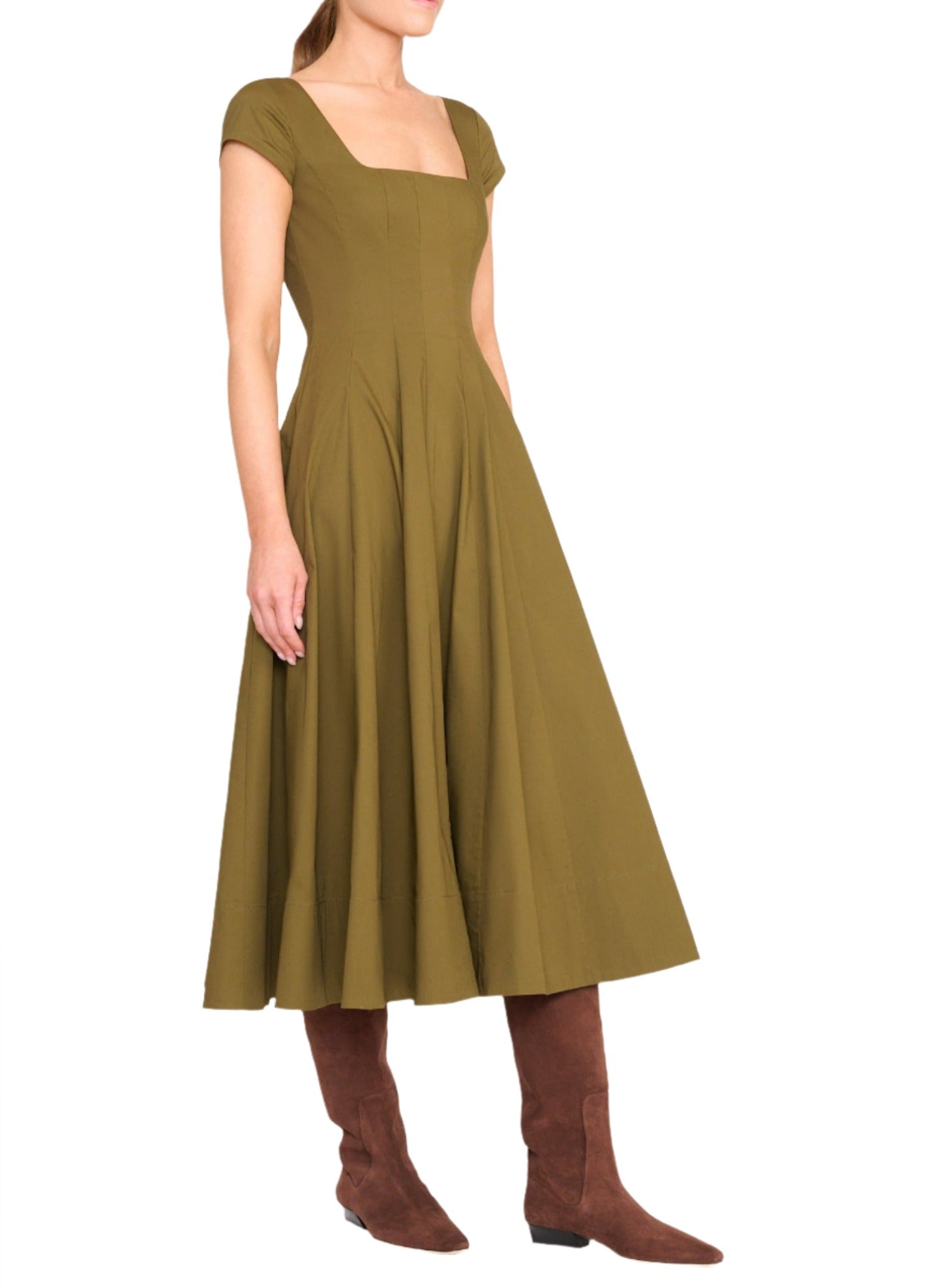 A person is wearing the Staud Wells SS Dress in olive green with short sleeves and a square neckline, paired with brown knee-high boots.