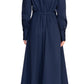 A person is shown from the back wearing the Staud Lorenza Midi Dress in navy blue, featuring long sleeves, a button-up front, and a fitted waist that reaches the calves. They are also wearing white slip-on shoes with perforations, and their hair is pulled back into a ponytail.