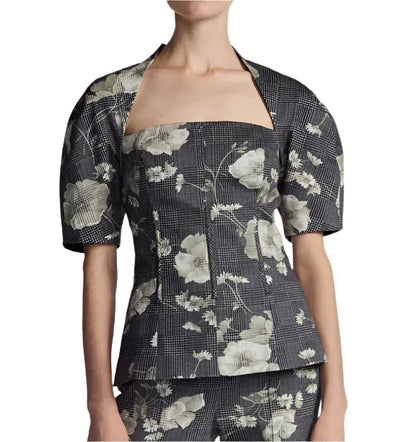 A person wearing the Lela Rose Bustier Top, a structured piece featuring a floral pattern, large sleeves, and a square neckline.