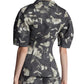 Back view of a person wearing the Lela Rose Bustier Top, a fitted, floral-patterned, short-sleeve jacket paired with matching pants, featuring a tailored bodice for an elegant silhouette.