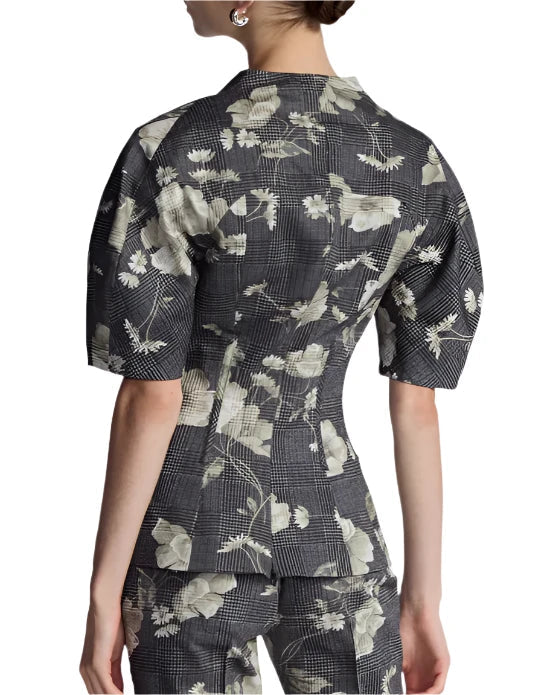 Back view of a person wearing the Lela Rose Bustier Top, a fitted, floral-patterned, short-sleeve jacket paired with matching pants, featuring a tailored bodice for an elegant silhouette.