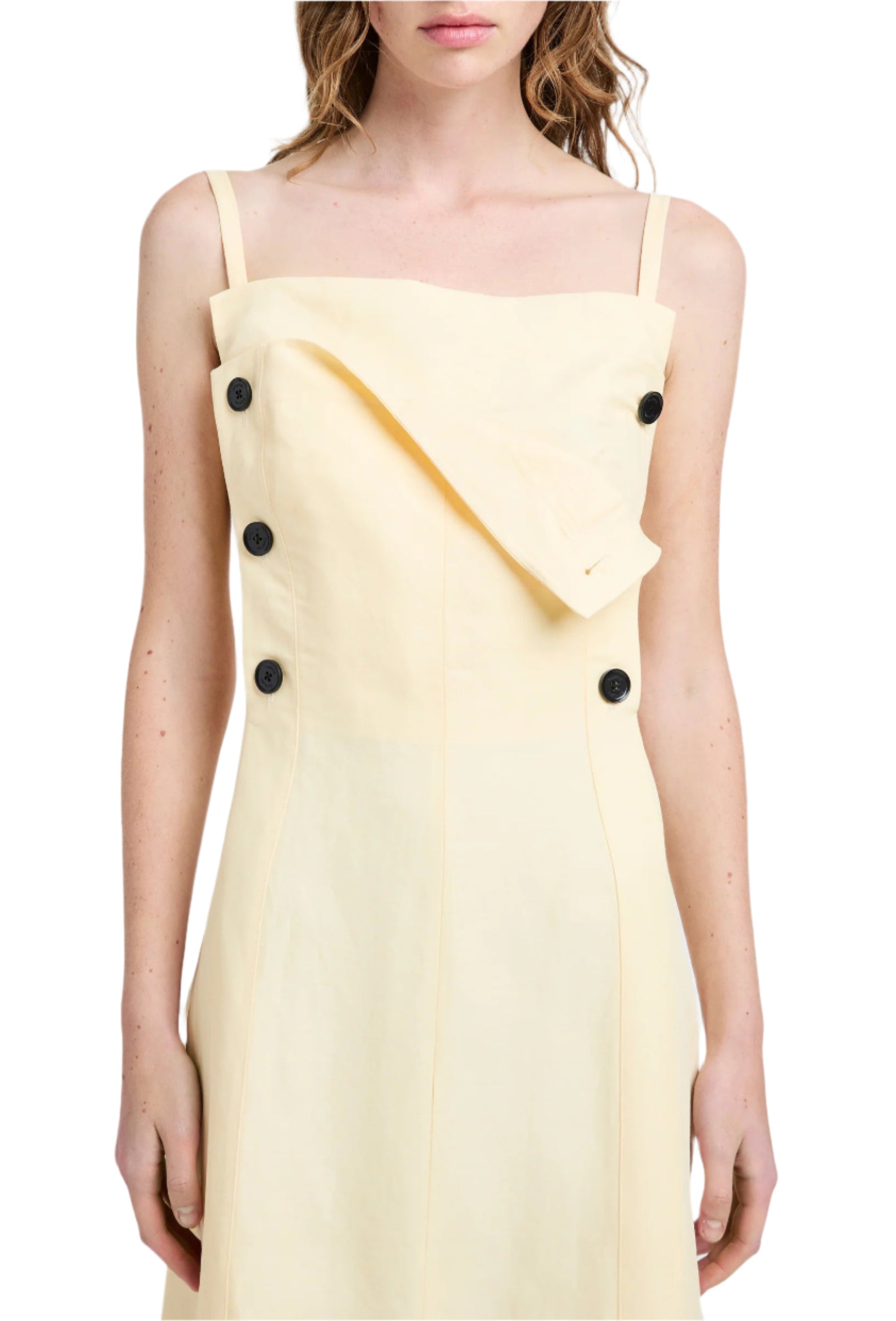 Front view of a person wearing the Candice Dress by Proenza Schouler, featuring a light yellow sailor-inspired design with black buttons and an asymmetrical flap detail.