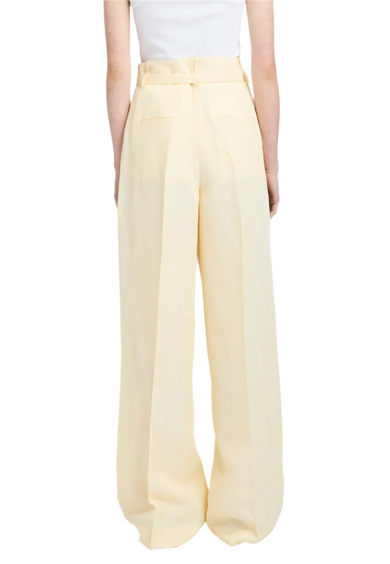 Back view of a person wearing Proenza Schouler's light beige Jules Pant, made from linen viscose, paired with a white top against a white background.