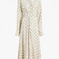 The Proenza Schouler Keria Printed Crepe De Chine Dress features long sleeves, a beige and white checkered print, a fitted waist, pleated front details, and a gathered twist for added elegance.