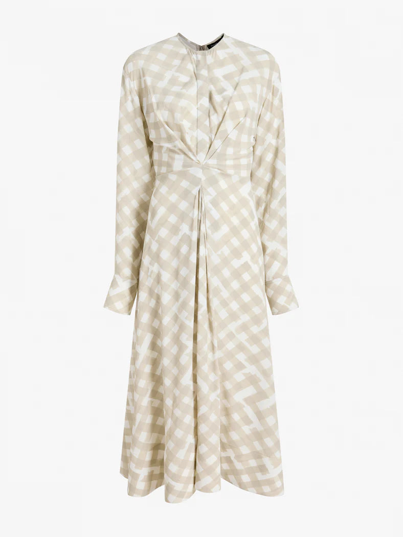 The Proenza Schouler Keria Printed Crepe De Chine Dress features long sleeves, a beige and white checkered print, a fitted waist, pleated front details, and a gathered twist for added elegance.