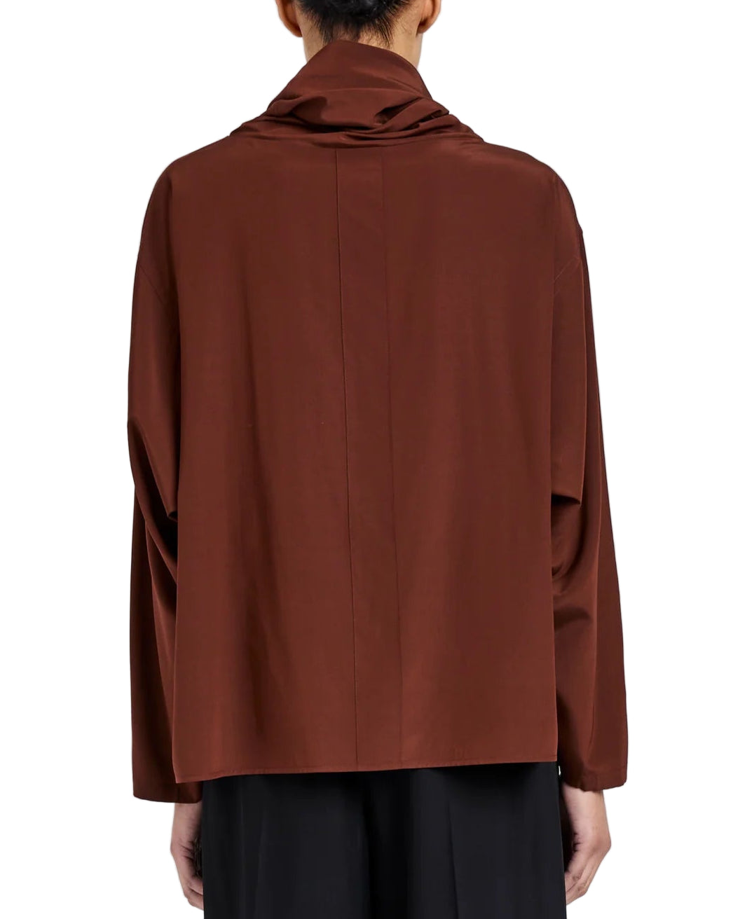 Person wearing the Solene Silk Viscose Top by Proenza Schouler, a loose-fitting, long sleeve brown top with a draped funnel neck, shown from the back.