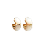 The Zellige Hoops by Lizzie Fortunato are handcrafted gold and white enamel half-hoop earrings with a smooth, rounded design inspired by Moroccan hoops, displayed on a white background.