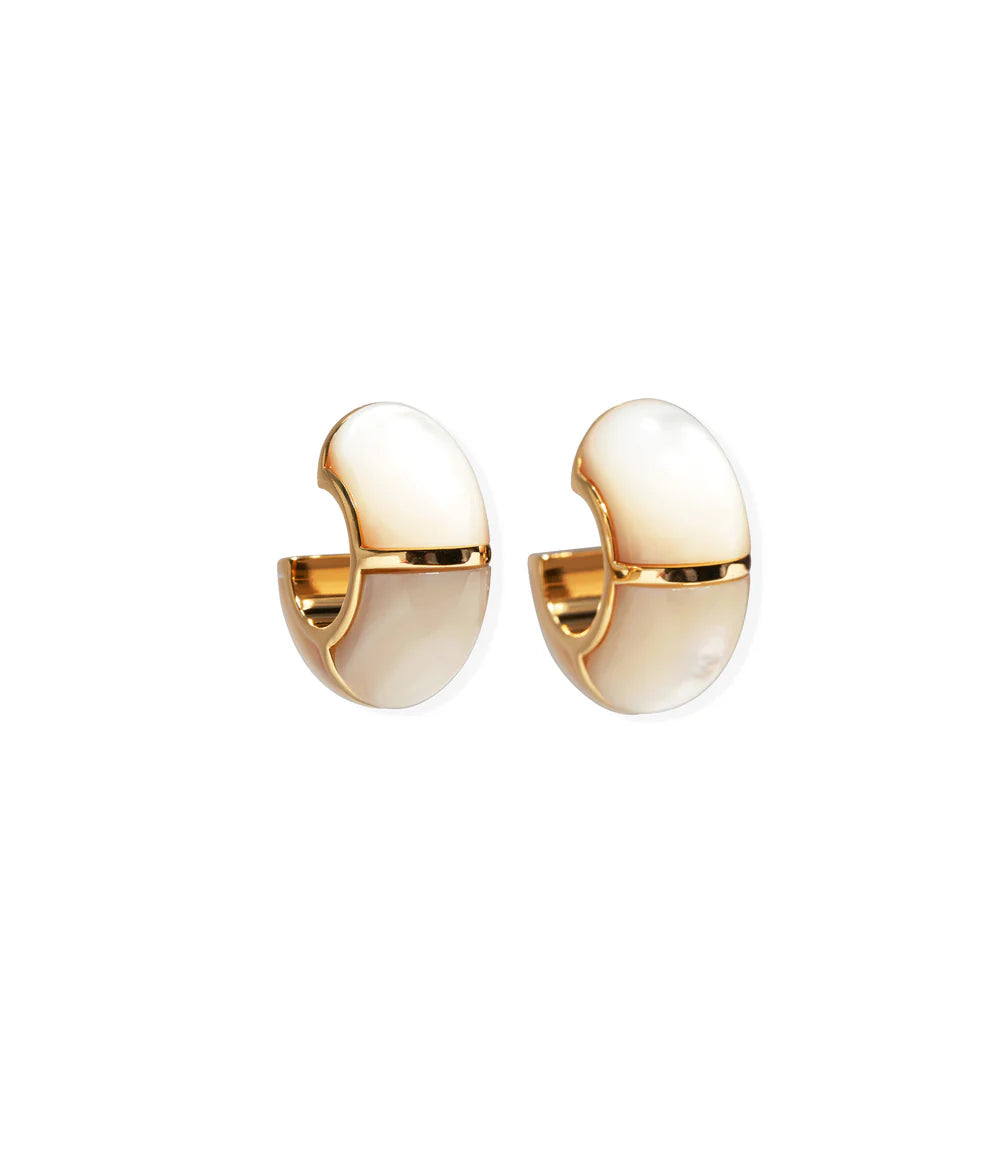 The Zellige Hoops by Lizzie Fortunato are handcrafted gold and white enamel half-hoop earrings with a smooth, rounded design inspired by Moroccan hoops, displayed on a white background.