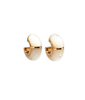 The Zellige Hoops by Lizzie Fortunato are handcrafted gold and white enamel half-hoop earrings with a smooth, rounded design inspired by Moroccan hoops, displayed on a white background.