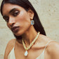Woman with straight dark hair wears a cream camisole, a gold-plated brass twisted necklace with a large pearl pendant, and Lizzie Fortunato Tile Earrings against a neutral background.