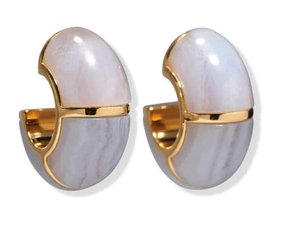 The Zellige Hoops by Lizzie Fortunato are handcrafted gold earrings with a glossy white and grey marbled outer coating, inspired by Moroccan designs, shown on a white background.