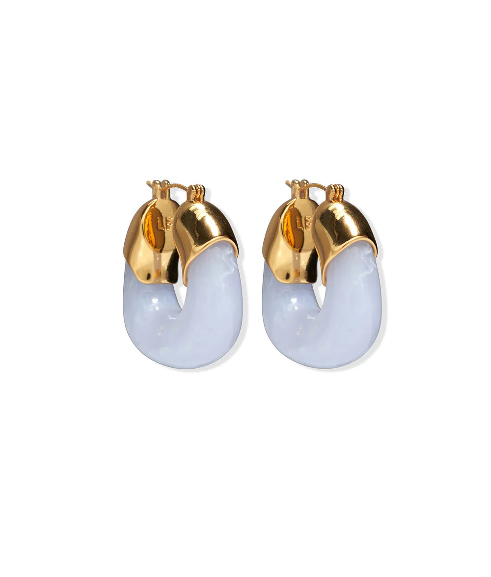 The Lizzie Fortunato Organic Gold Hoops are resin earrings with glossy light blue curved bands and gold-tone metal caps and clasps, shown on a white background.