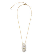 La Paz Pendant Necklace by Lizzie Fortunato: gold-plated chain with a white oval ceramic talisman featuring two inset stones—one iridescent, one green—set against a white background.