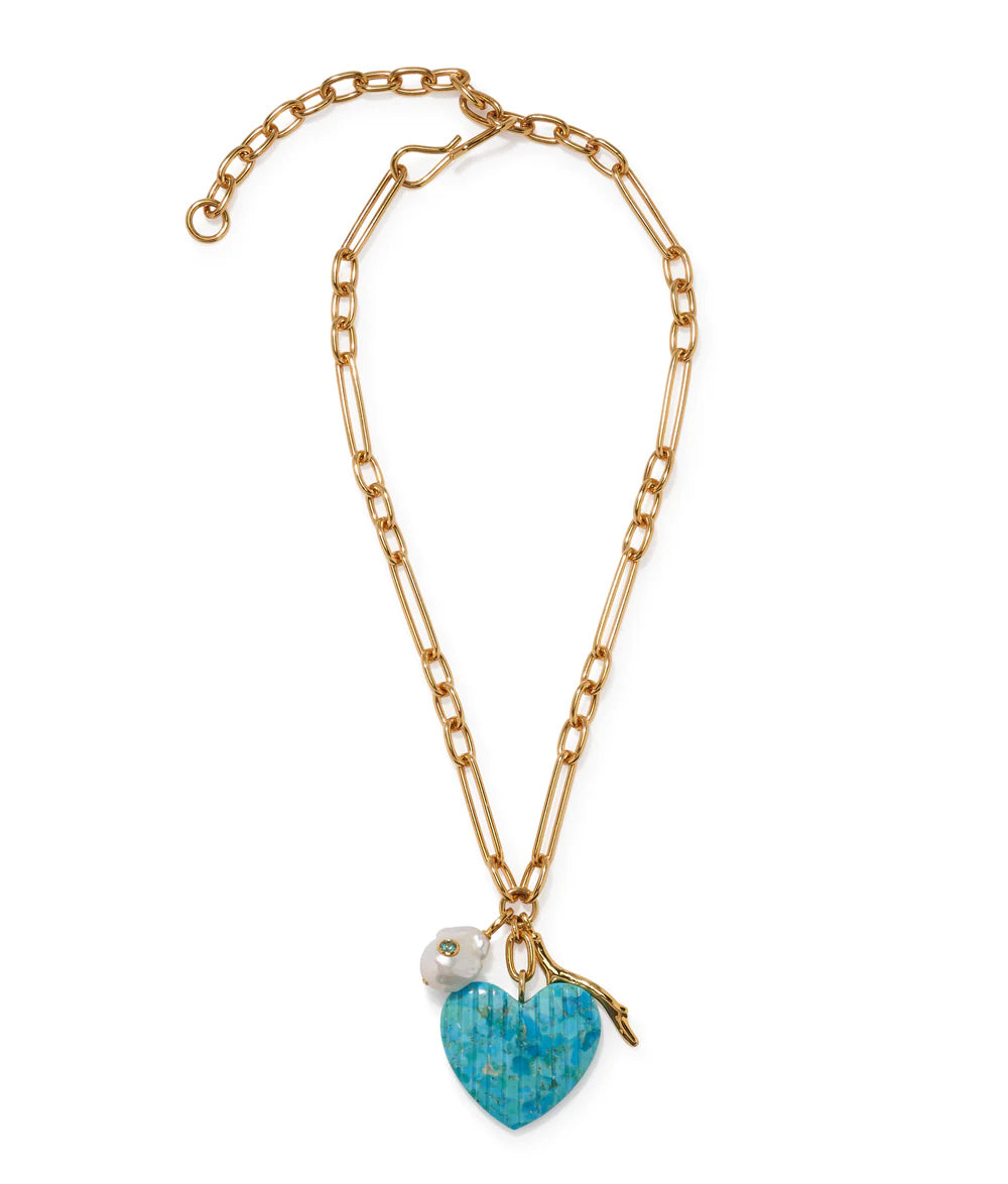 The Floria Heart Necklace by Lizzie Fortunato features a gold-plated chain, turquoise heart pendant with blue mosaic, white flower charm, and adjustable clasp—an ideal statement piece for any occasion.