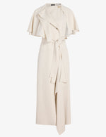 The Isolde Dress by Proenza Schouler is a cream, sleeveless, ankle-length dress in Viscose Twill with a trench-inspired draped cape, notch collar, and matching fabric belt at the waist.