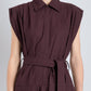 A person models the Proenza Schouler Adinna Dress—a sleeveless, collared, plum cotton shirting dress with a waist belt—against a plain light background.