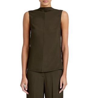 A person wears the Proenza Schouler Defni Top—a sleeveless, draped high-neck design in dark olive green Eco Hammered Viscose—paired with matching trousers, seen from the front against a white background.