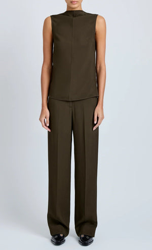 A model wears the Proenza Schouler Defni Top, a sleeveless olive brown piece with a draped high neckline in Eco Hammered Viscose, paired with matching wide-leg trousers against a plain light background.