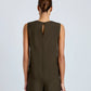 A woman with her hair in a low bun faces away, wearing the Proenza Schouler Defni Top in olive-green Eco Hammered Viscose, featuring a draped high neckline, keyhole back, and matching pants.