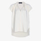 The Ranli Top by Proenza Schouler is a white short-sleeve style with a V-neck and a relaxed fit, expertly crafted from Matte Double Crepe for a luxurious feel. It features a draped collar, high-low hem, and soft draping on a plain background.