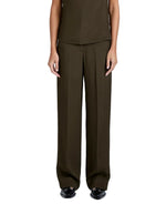 A person wears the Proenza Schouler Lien Pant in dark olive Eco Hammered Viscose, styled high-waisted and wide-leg, with black shoes. Arms are relaxed at their sides and the view is from the waist down.