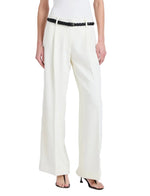 A person wearing the Proenza Schouler Halima Pant in white matte double crepe with pleats, styled with a black braided belt and black heeled sandals. Upper body is not shown.