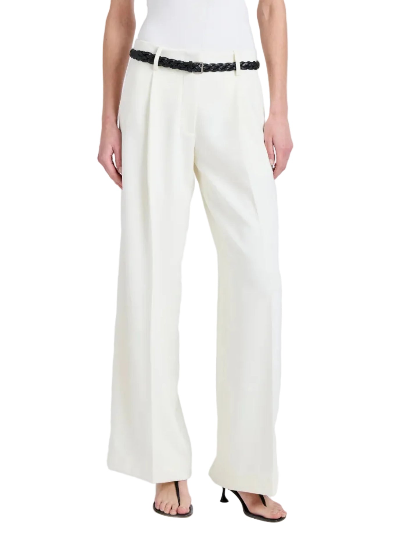 A person wearing the Proenza Schouler Halima Pant in white matte double crepe with pleats, styled with a black braided belt and black heeled sandals. Upper body is not shown.