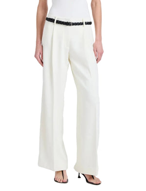 A person wearing the Proenza Schouler Halima Pant in white matte double crepe with pleats, styled with a black braided belt and black heeled sandals. Upper body is not shown.