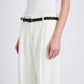 A person shown from shoulders to mid-thigh against a plain background wears a sleeveless white top, the Proenza Schouler Halima Pant in matte double crepe with a high waist, and a black braided belt.