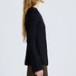 A person with long, wavy hair models the Proenza Schouler Sukki Jacket in side profile against a plain light gray background.
