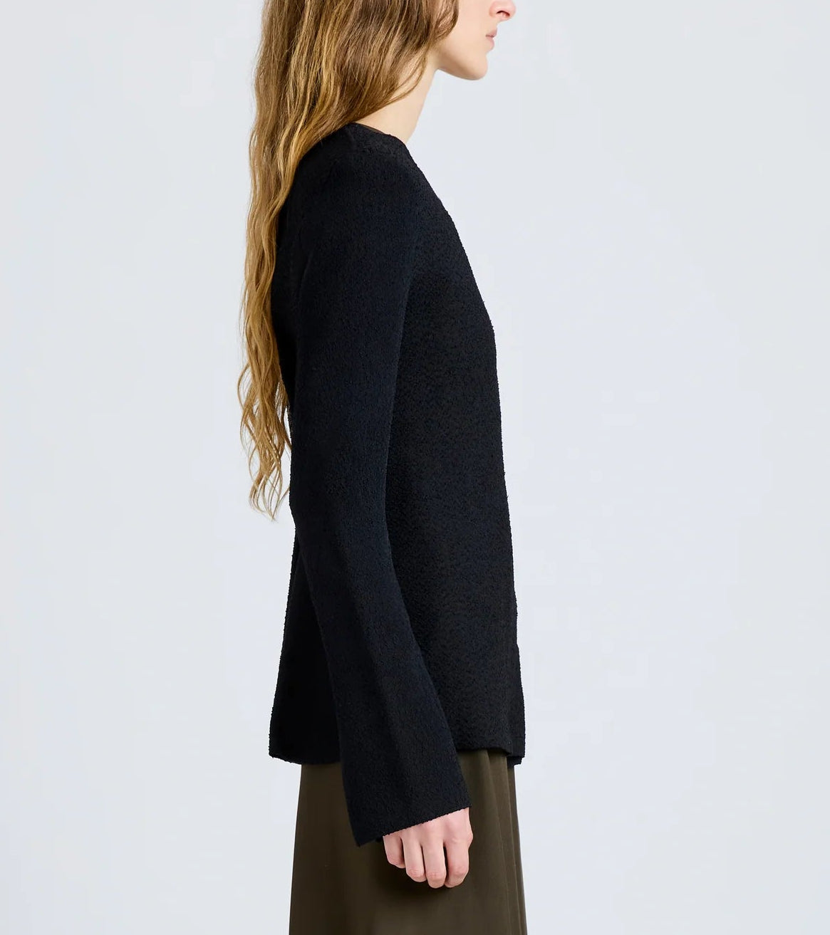 A person with long, wavy hair models the Proenza Schouler Sukki Jacket in side profile against a plain light gray background.