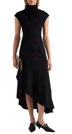 A person wearing the Elodine Tropical Wool Dress by Proenza Schouler—a sleeveless, black asymmetrical midi dress with a high neck crafted from luxurious tropical wool—paired with a striped clutch and black pointed-toe kitten heel shoes.
